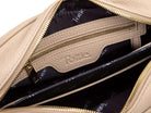 The interior of a stone-colored leather crossbody bag. The lining is black with the brand name "Tottie" printed in gold repeatedly. There is a gold-toned zipper, a black card slot, and a gold-toned metal plate with the brand name "Tottie"