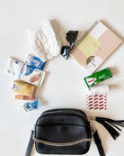 Black Crossbody Bag from Tottie Filled with Baby Essentials and Personal Care Items