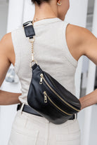 Woman showing off a black and gold hardware bum bag or belt bag from Tottie worn on her back